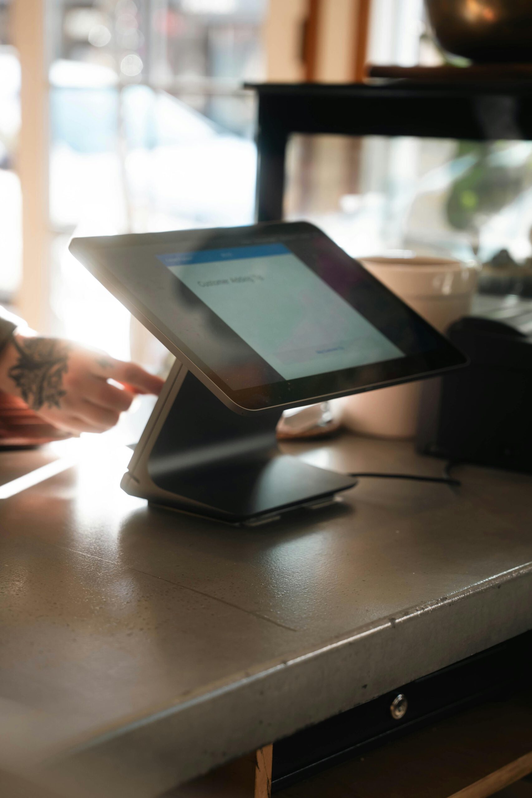 A sleek tablet point-of-sale system in a stylish coffee shop environment.